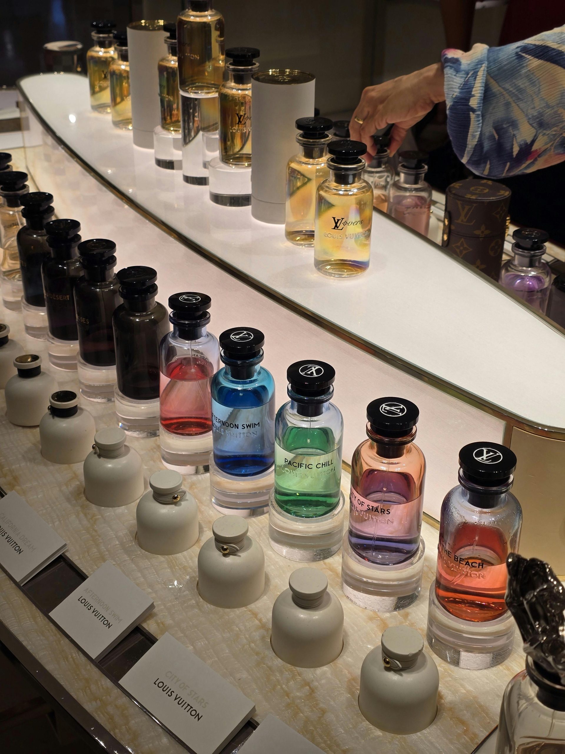 A vibrant display of luxury perfume bottles in various colors and fragrances.